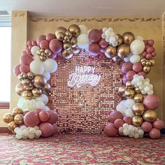 an arch made out of balloons with the words happy birthday written in white and gold