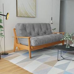 a living room with a couch, coffee table and potted plants on the floor