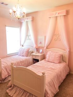 two twin beds in a pink bedroom with chandelier