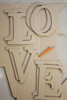 the word love is cut out of cardboard and ready to be put into an art project