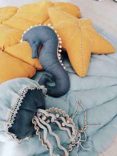 an assortment of pillows and cushions on a bed