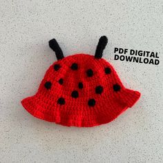 a red crocheted hat with black dots on it