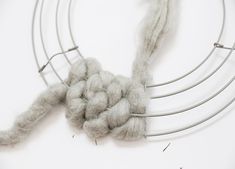 a close up of a piece of yarn on a circular wire rack with scissors and thread