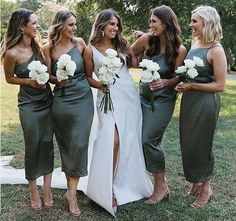 the bridesmaids are all dressed in green dresses and holding bouquets with white flowers