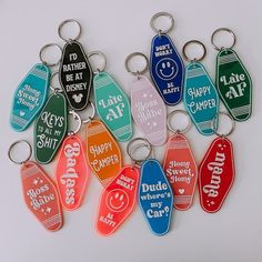 a bunch of key chains with different colors and designs on them that say happy camper