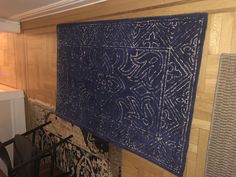 a blue rug hanging on the side of a wooden wall
