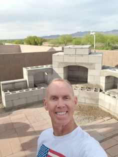 a man standing in front of a building with an american flag t - shirt on