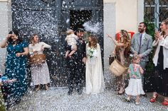 a group of people standing around each other in front of a building with confetti