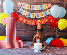 a baby sitting in front of a birthday cake