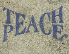 the words teach written in blue chalk on concrete