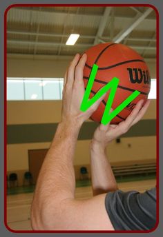 a man holding a basketball with an arrow pointing to it in front of his face