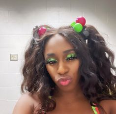 a woman with green makeup and fruit decorations on her head is posing for the camera