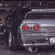 the back end of a silver car in a garage