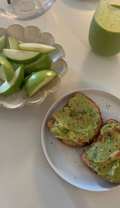 two pieces of bread on a plate with avocado