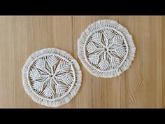 two white woven coasters sitting on top of a wooden table