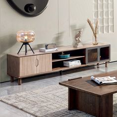 a living room scene with focus on the coffee table and entertainment center, as well as an abstract wall clock