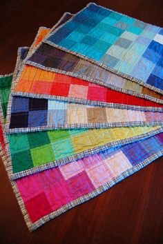 four different colors of fabric laid out on top of each other in the shape of squares