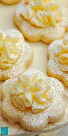 there are many cookies with white frosting on the top and one has a flower