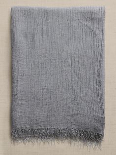 a gray blanket with fringes on it