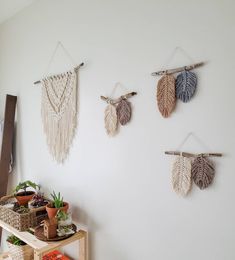 three wall hangings made out of macrame leaves on a white wall in a room