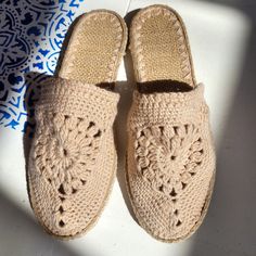 a pair of crocheted slippers sitting on top of a white floor next to a blue and white wall