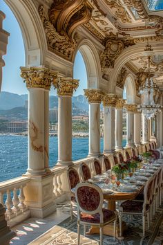 an ornate dining room with columns and chandeliers overlooking the water in monaco, italy