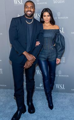 a man and woman standing next to each other on a blue carpet