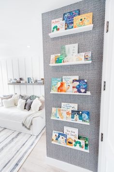 a wall mounted book rack with books on it in a living room next to a white couch