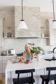 a woman is sitting at the kitchen counter