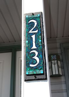 a house number sign hanging from the side of a building