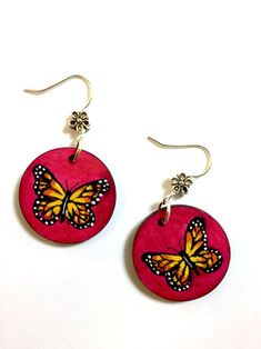 pair of pink earrings with yellow and black butterflies