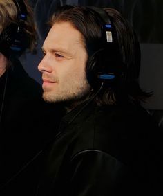 two men wearing headphones sitting next to each other