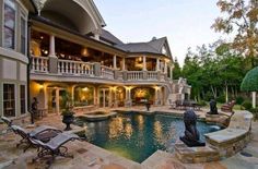 a large house with a swimming pool in the front yard and an outdoor dining area