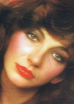 a close up of a woman with red lipstick on her face and long brown hair