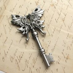 an ornate key is sitting on top of a piece of paper