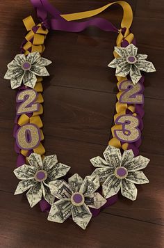 a purple and gold necklace with money on it that says $ 10 00 in large letters