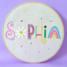 a white embroidered wall hanging with the word appliqued on it's side