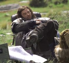 a man sitting in the grass with his eyes closed