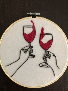 two hands holding wine glasses in each other's hand, with red thread on them