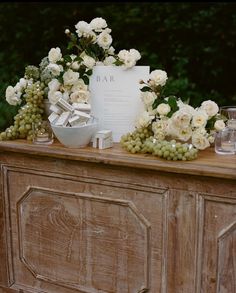 a table topped with white flowers and greenery