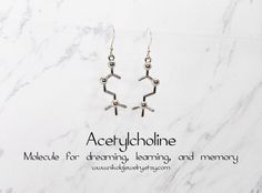 "Silver Acetylcholine Earrings. Acetylcholine is the molecule responsible for triggering dreaming, memory and learning - making these tiny earrings the perfect little gift for that space cadet in your life. Allow this piece to help the wearer keep both feet on the ground and their head out of the clouds! Molecule measures: 1.3 x 3.5 cm (0.5 x 1.4\") Purchase includes a molecule information card, a natural jewelry box, and gift packaging. Gift? Add-on a hummingbird card for only $7: https://www.e Hummingbird Card, Random Knowledge, Custom Tattoos, Ears Pierced, Space Cadet, Science Jewelry, Natural Jewelry, Information Card, Necklace Extender