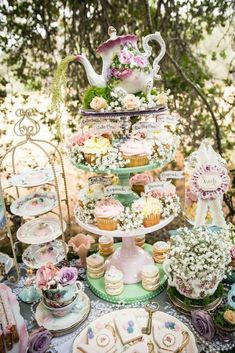 a table topped with lots of cakes and cupcakes