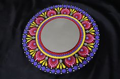 a colorful mirror sitting on top of a black cloth