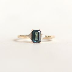 An emerald cut black diamond stone flanked by trillion cut diamonds. This unique diamond engagement ring combines sharp sophistication with a fashionable twist. Black Diamond Engagement Ring, Cute Engagement Rings, Black Diamond Engagement, Unique Diamond Engagement Rings, Vintage Fine Jewelry, Engagement Ring Diamond Cut, Black Diamond Ring Engagement, Dream Engagement Rings, Unique Diamonds