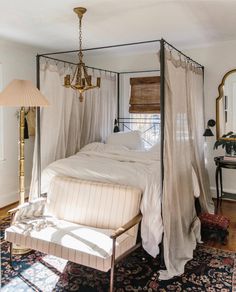 a canopy bed in a bedroom with white walls