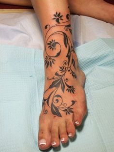 a woman's foot with flowers and vines on it