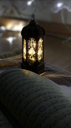 an illuminated lantern sitting on top of a bed