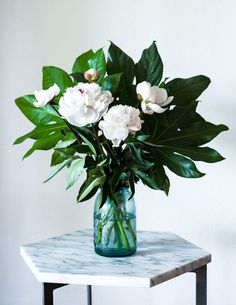 a vase filled with white flowers on top of a table