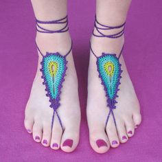 a woman's feet with crocheted barefoot sandals on top of purple background