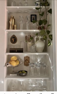 a shelf filled with glasses, lemons and other items